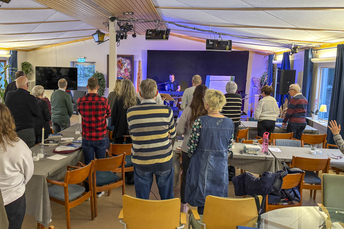 personer står upp och ber under bönemöte